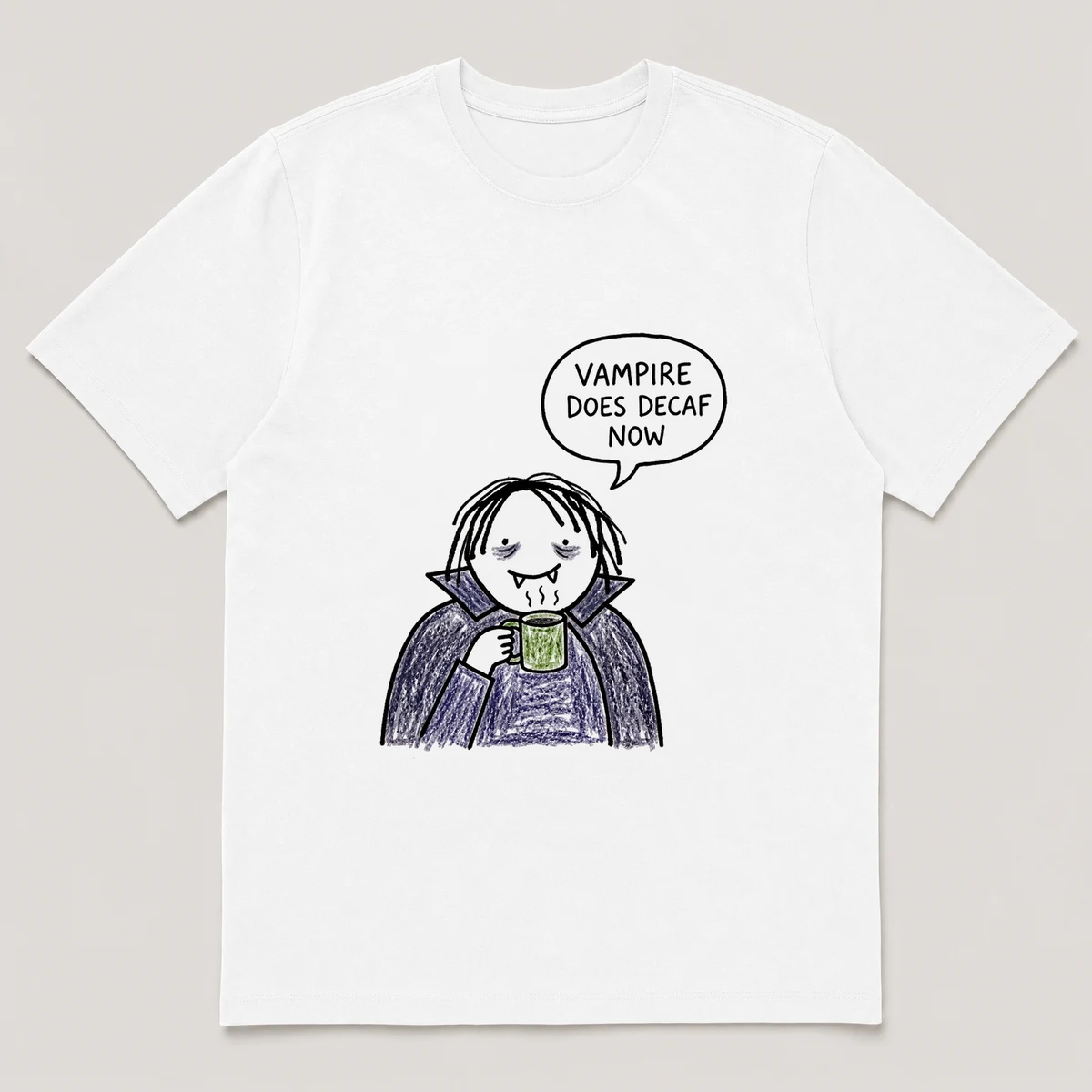 Front view of a White Tee printed with pale vampire sips a small mug with visible bags under its eyes and the caption VAMPIRE DOES DECAF NOW, White front view